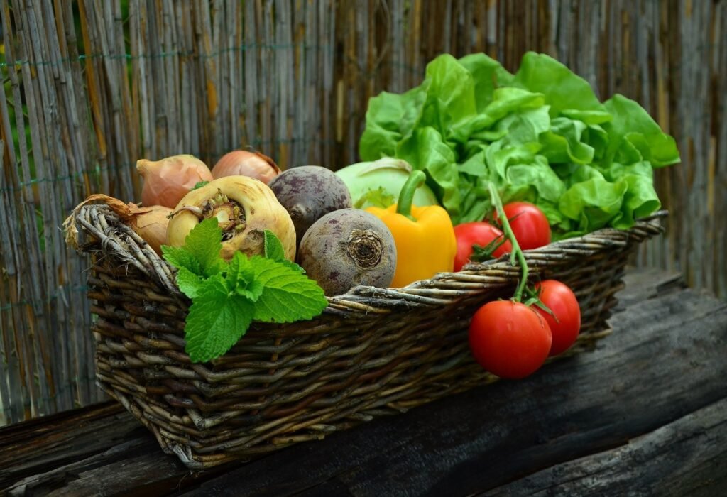 Frisches Gemüse im Korb: Tomaten, Zwiebeln, Salat und Kräuter aus einem selbstregulierender Garten