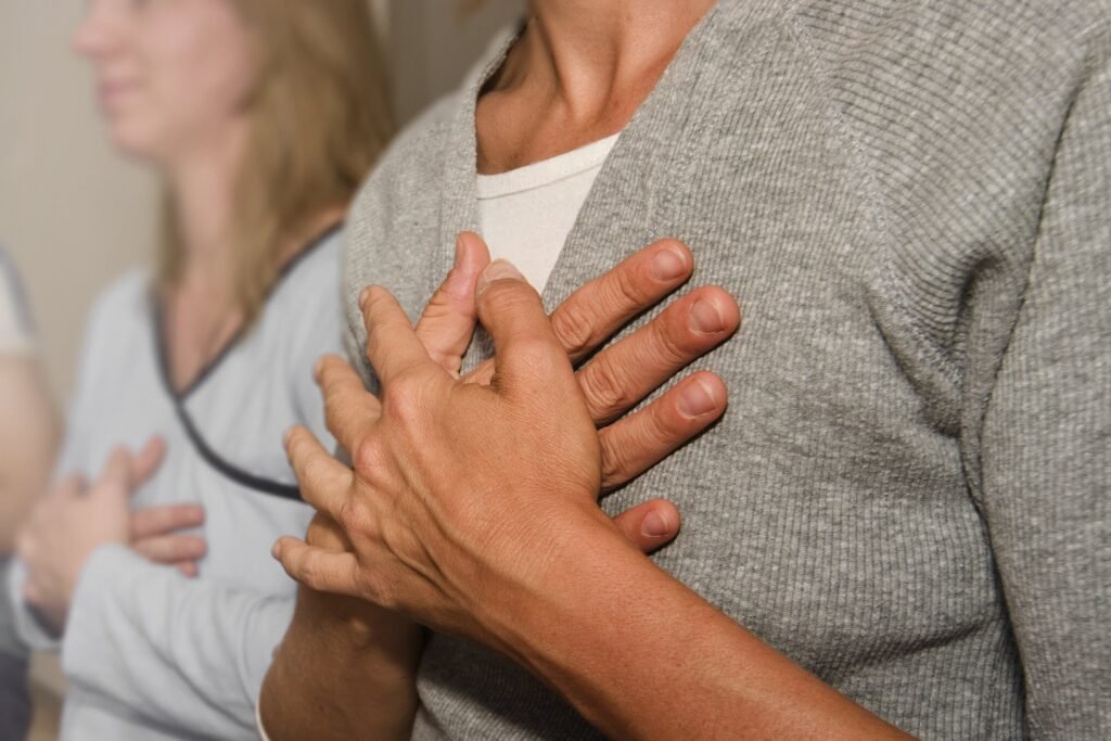 Menschen halten sich die Hände über das Herz – eine Geste, die zeigt, wie dein Körper mit dir spricht