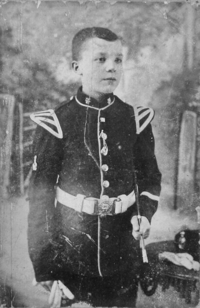 Kind in alter Militäruniform – Symbolbild für frühe Prägung durch Krieg und Klassengesellschaft