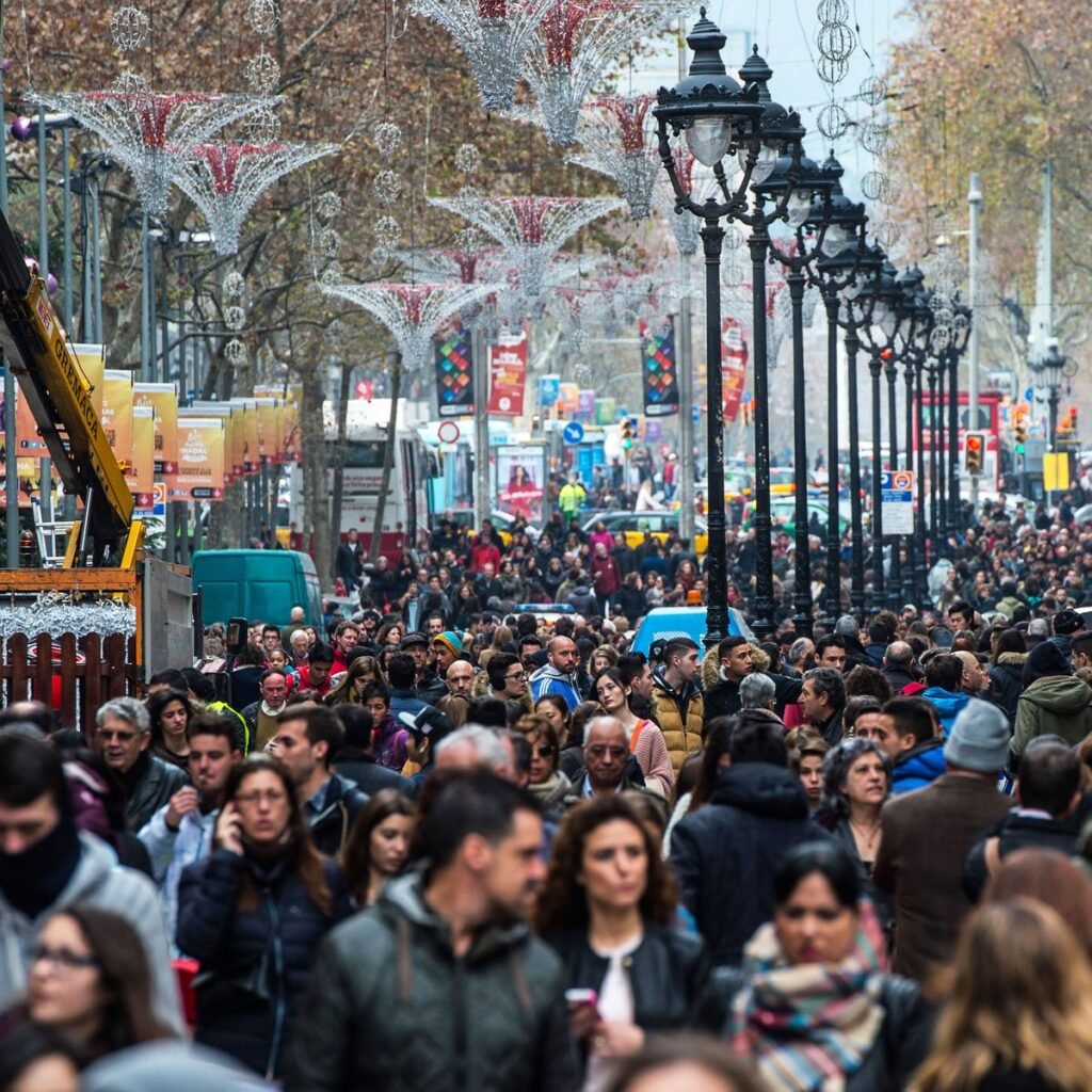 Menschenmasse in einer überfüllten Einkaufsstraße – Ausdruck urbaner Systemabhängigkeit