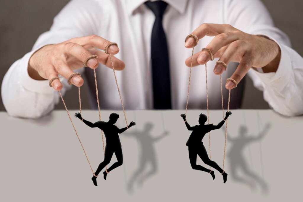 Manipulation durch Medien symbolisiert durch Marionetten, die von unsichtbaren Fäden gesteuert werden